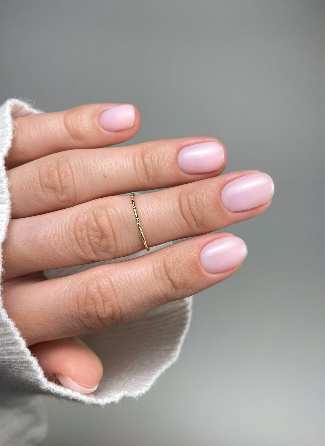 Soft milky pink natural nails with clean glossy overlay and short almond shape manicure inspiration by GLOSS