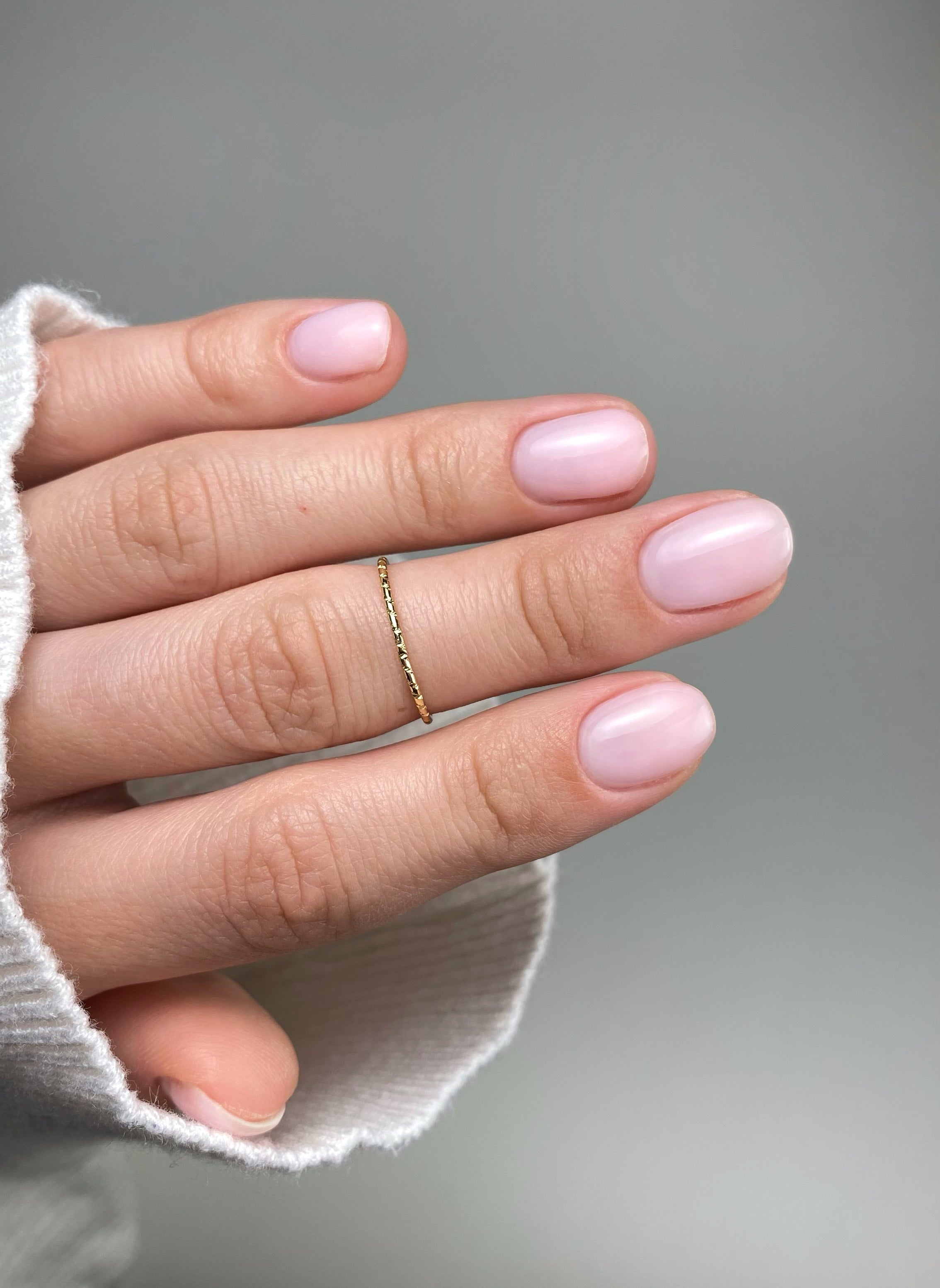 Soft milky pink natural nails with clean glossy overlay and short almond shape manicure inspiration by GLOSS