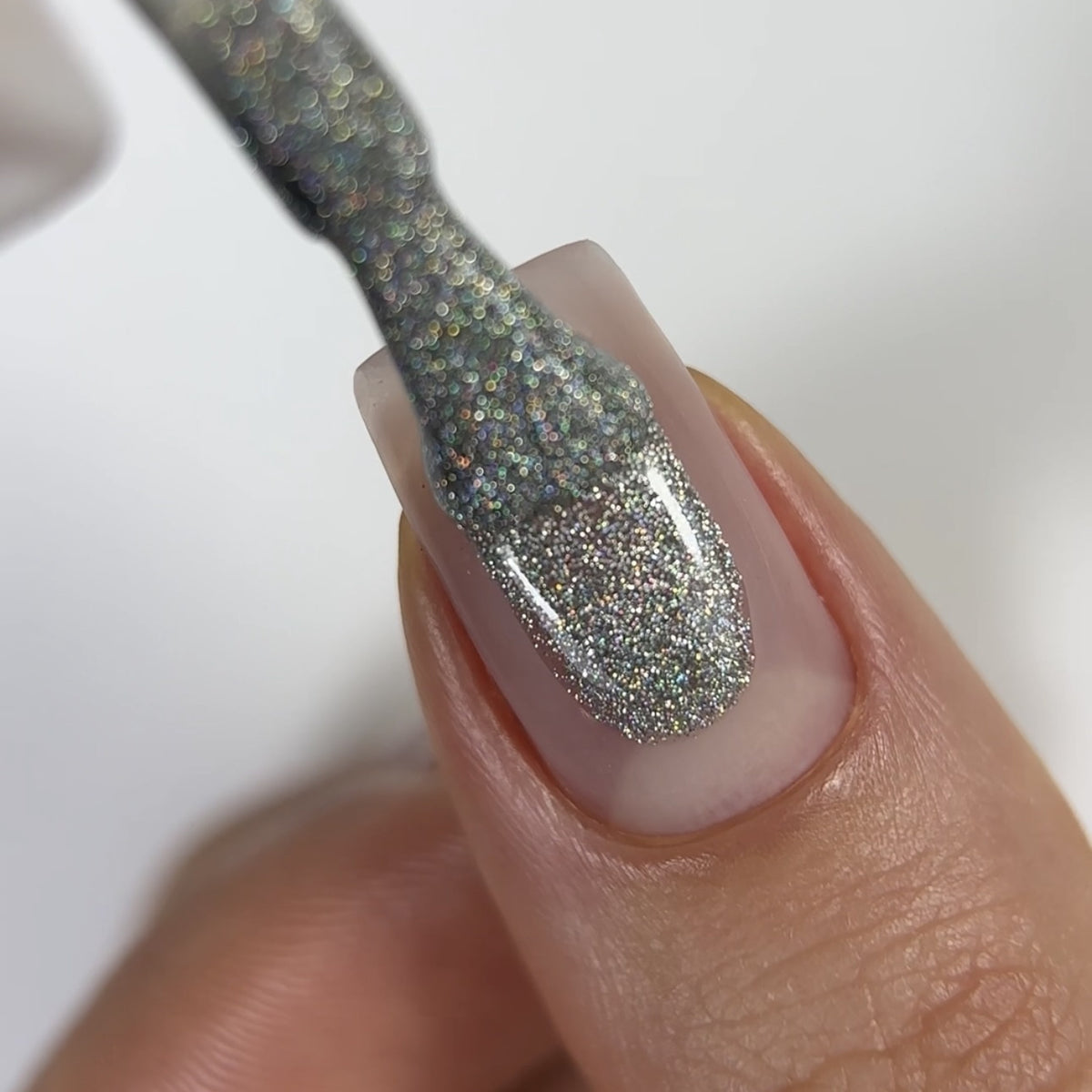 Silver Holographic gel manicure: GLOSS 401 gel polish on a nail, close-up photo